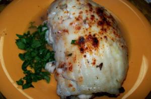 Grilled fish fillet with herbs on plate.