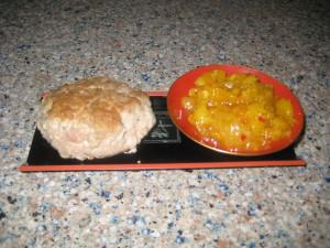 Biscuit and chutney on red-bordered tray.