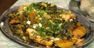 Colorful vegetable and herb dish on platter.