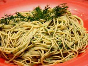 Herb pesto spaghetti garnished with fresh dill