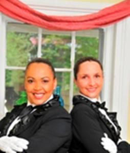 Two women in formal attire, smiling.
