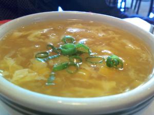 A bowl of soup with green onions on top.