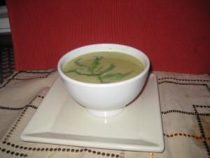 Bowl of green soup with garnish.