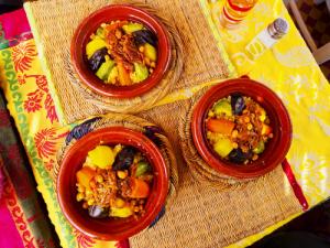 Three colorful vegetable tagines on woven placemats