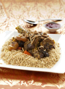 Couscous with meat and nuts on plate.