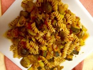 A white bowl filled with pasta and meat.