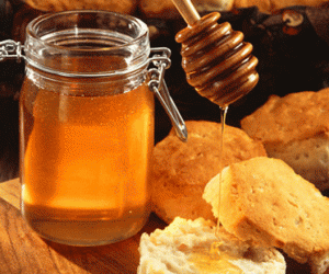 A jar of honey and some crackers on the table