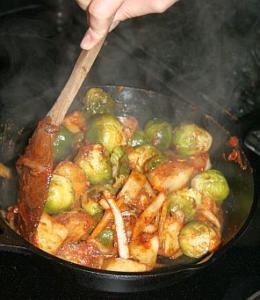 Cooking Brussels sprouts and vegetables in skillet.