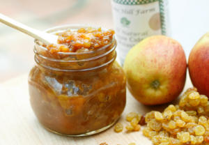 Jar of apple chutney with apples.