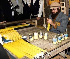 Man crafting candles at rustic wooden table.