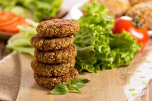 A stack of four falafel next to some salad.