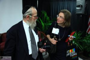 Two people engaged in conversation, holding items.