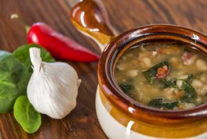 Clay bowl of bean and spinach soup