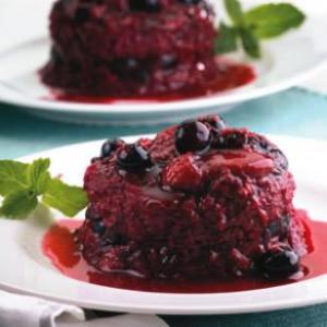 Two plates of cake with berries on top.