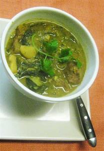 Bowl of soup with herbs and vegetables.