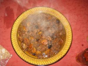 Steaming bowl of Moroccan tagine on table.