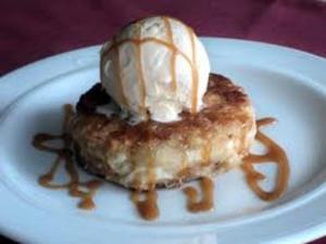 Caramel-drizzled bread pudding topped with ice cream