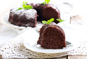 A chocolate bundt cake sitting on top of a white plate.