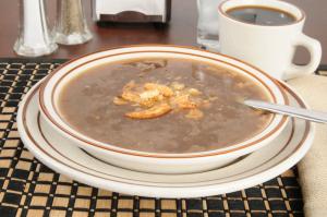 A bowl of soup on the table with a spoon.