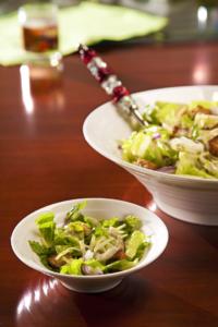 Salad in bowls on wooden table.