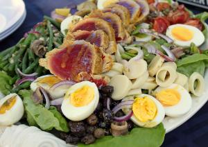 A salad with eggs, olives and other vegetables.