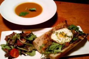 Soup, sandwich, and salad on a table.