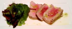 Seared tuna with greens on plate.
