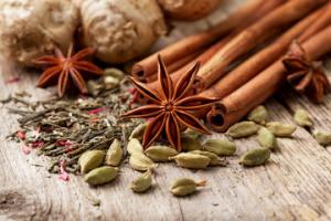 A table topped with spices and herbs on top of a wooden surface.