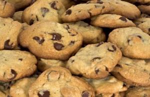 A pile of chocolate chip cookies sitting on top of each other.