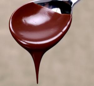 A spoon with chocolate sauce on it.
