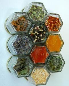 A bunch of different spices in glass containers