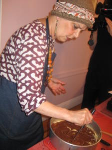 A woman in an apron is cutting paper.