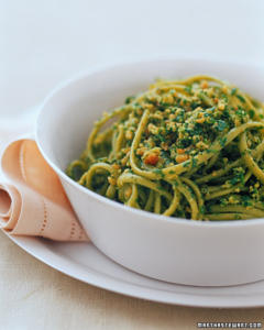 Bowl of pasta with green pesto sauce.