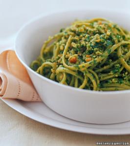 Green pesto spaghetti in white bowl