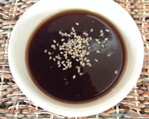 A bowl of soup with sesame seeds on top.