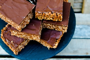 A plate of chocolate covered rice krispie treats.