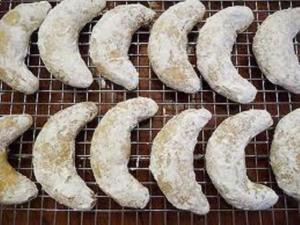 Powdered crescent cookies on cooling rack.