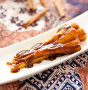 Plantains with sauce on white plate.