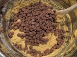 Cookie dough with chocolate chips and spoon.
