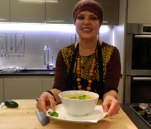 Woman presenting a bowl of soup.