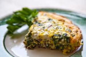 Slice of vegetable frittata on plate.