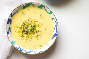 A bowl of soup with yellow and blue design.