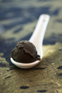 Black ice cream in a white spoon.