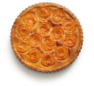 A close up of an apple pie on a white surface