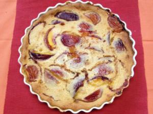 Peach tart on red and orange cloth.
