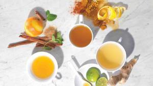 A table with cups of tea and bowls of food.