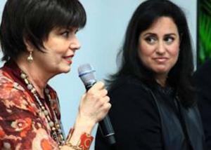 A woman is holding a microphone and talking to another person.