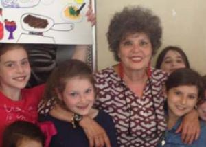 Older woman surrounded by smiling children