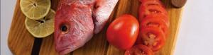 A close up of meat and tomato on a wooden surface