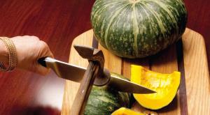A watermelon and some yellow squash on a cutting board.
